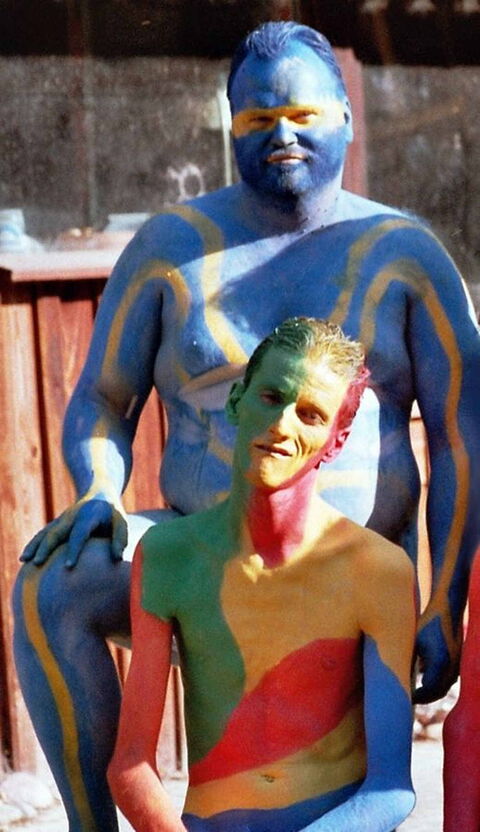 Foto: Andi (vorne sitzend) und ich (hinten stehend) nackig und bunt bemalt beim Bodypainting.