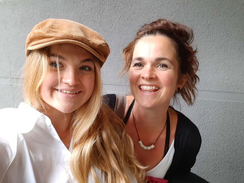 Mimi (links) mit Schirmmütze und ihre Mutter Lou (rechts) lächeln in die Kamera.