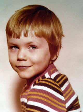 Foto: Dieses Bild zeigt mich mit etwa 5 Jahren in einem rot-gelb-braun-weißen Ringelpulli.