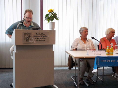 Foto: Eine Frontalaufnahme von mir (links im Bild) und einem Teil des Podiums (rechts im Bild).