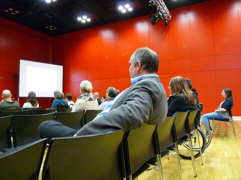 Foto: Hier ein Blick quer durch den ganzen Saal - aufgenommen aus den hinteren Reihen. Im Hintergrund links die Leinwand der Schriftdolmetscherin.