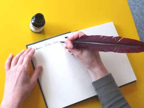 Foto: Hier schreibe ich mit Tinte und Feder einen Text in ein leeres Buch.