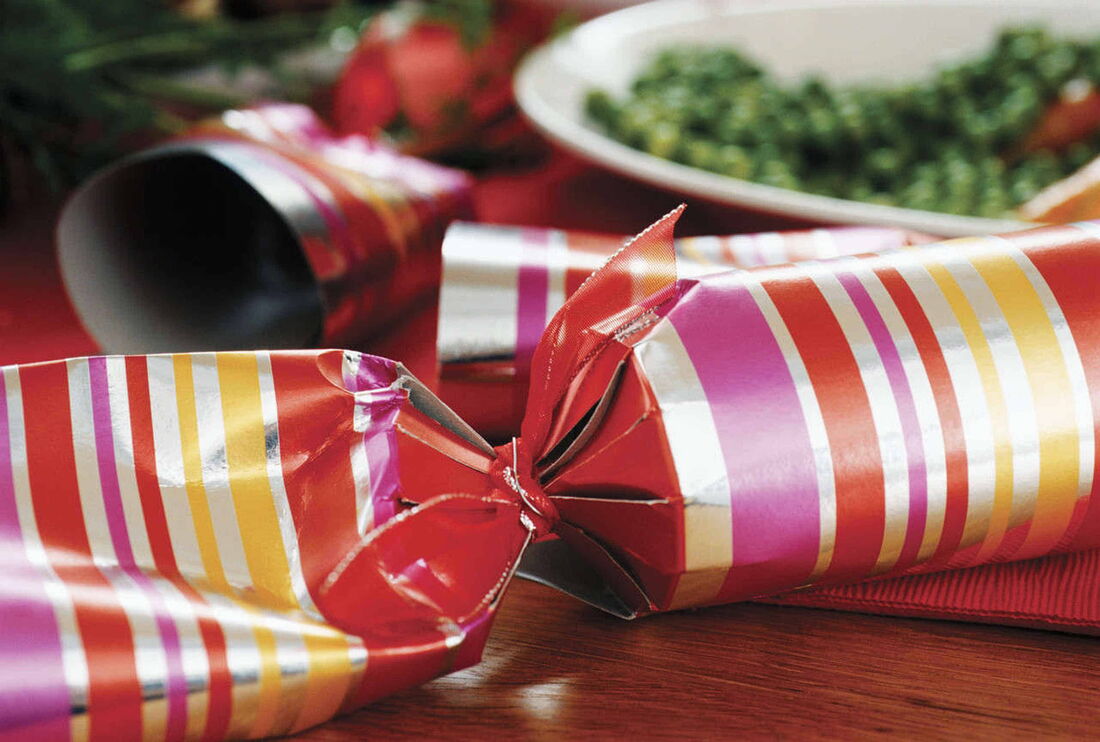 Foto: Ein bunt eingepacktes Geschenk liegt auf einem Tisch.