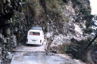 Foto: Unser Campingbus an einem Steilhang auf einermaroden hölzernen Brücke.