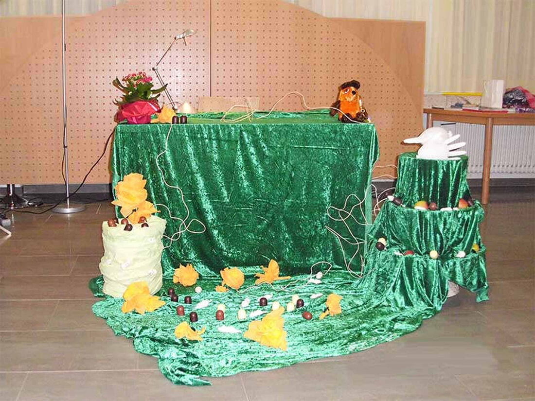 Foto: Ein reich dekorierter Vorlesetisch samt Anhängen bei meiner zweiten Lesung in Saarbrücken.