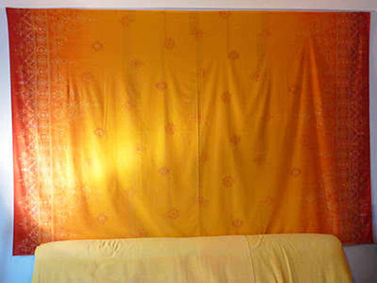 Foto: Ein großes, gelb-orange-rotes Wandtuch aus meinem Snoozleraum.