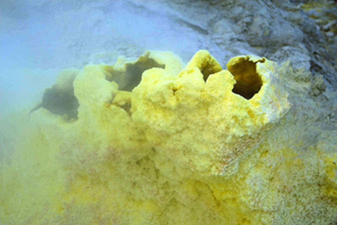 Foto: Eine schwefel-gelbe heiße Quelle öffnet sich im Boden.