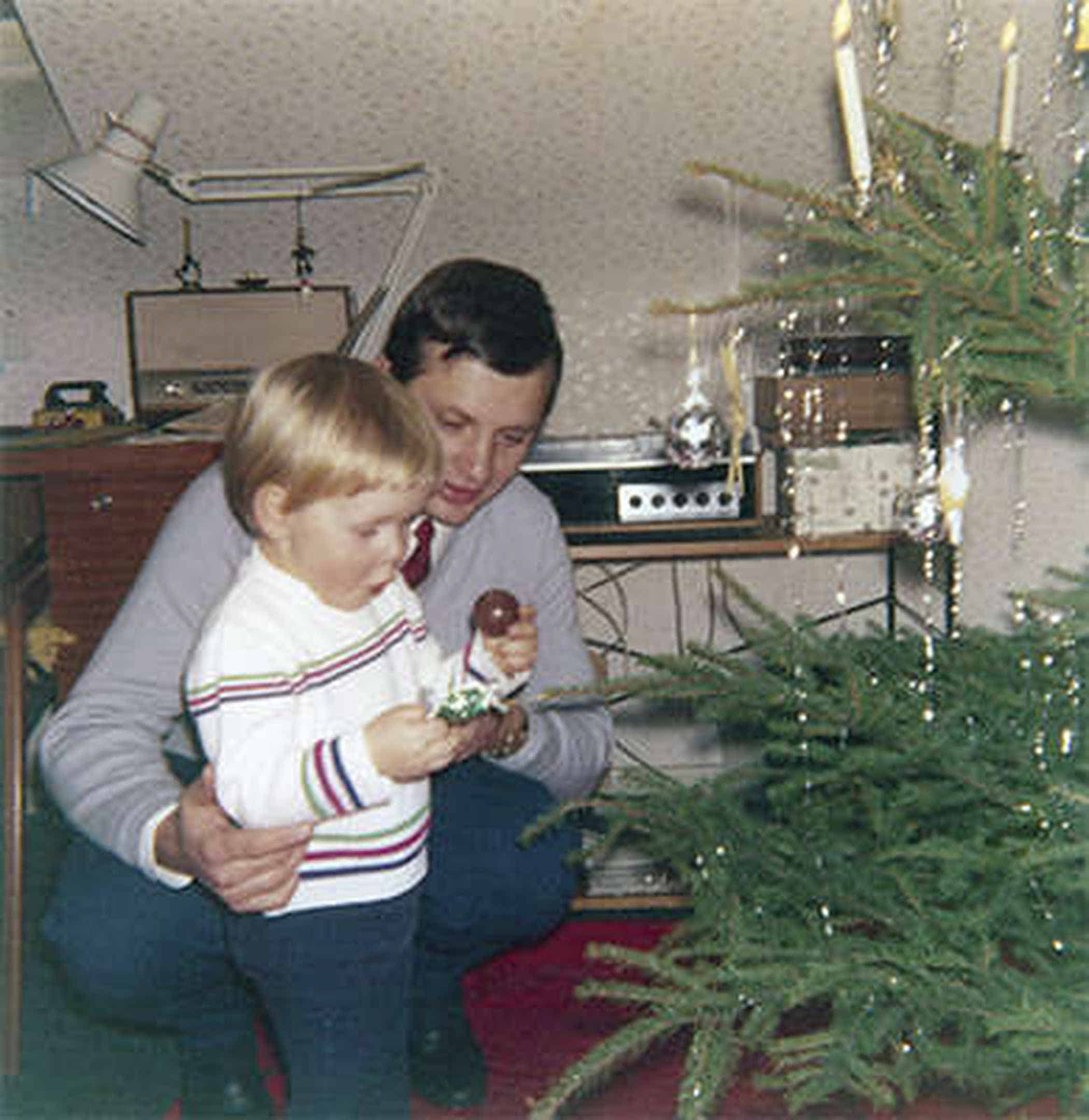 Foto: Mein Vater steht mit mir vor unserem Weihnachtsbaum. Ich bin etwa 3 Jahre alt.